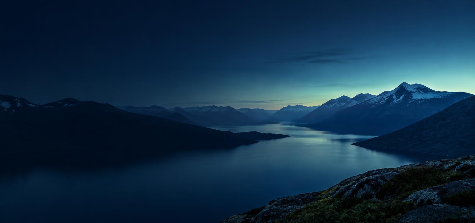Mountain ranges and a calm lake at blue hour